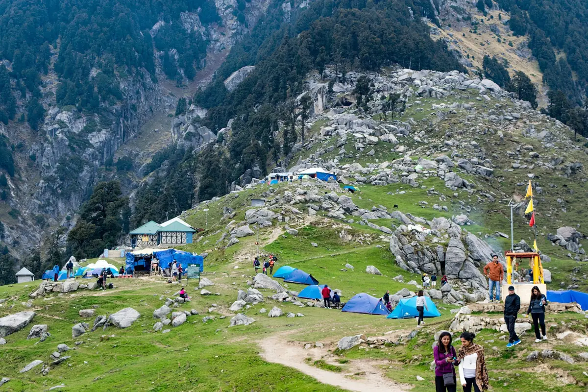 The grassy ridge of Triund with tents and huts
